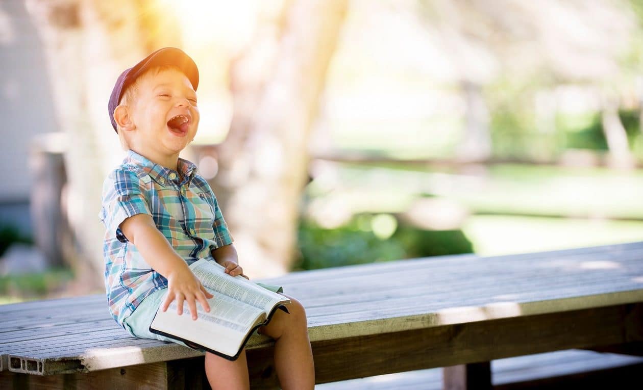 kid reading book and laughing
