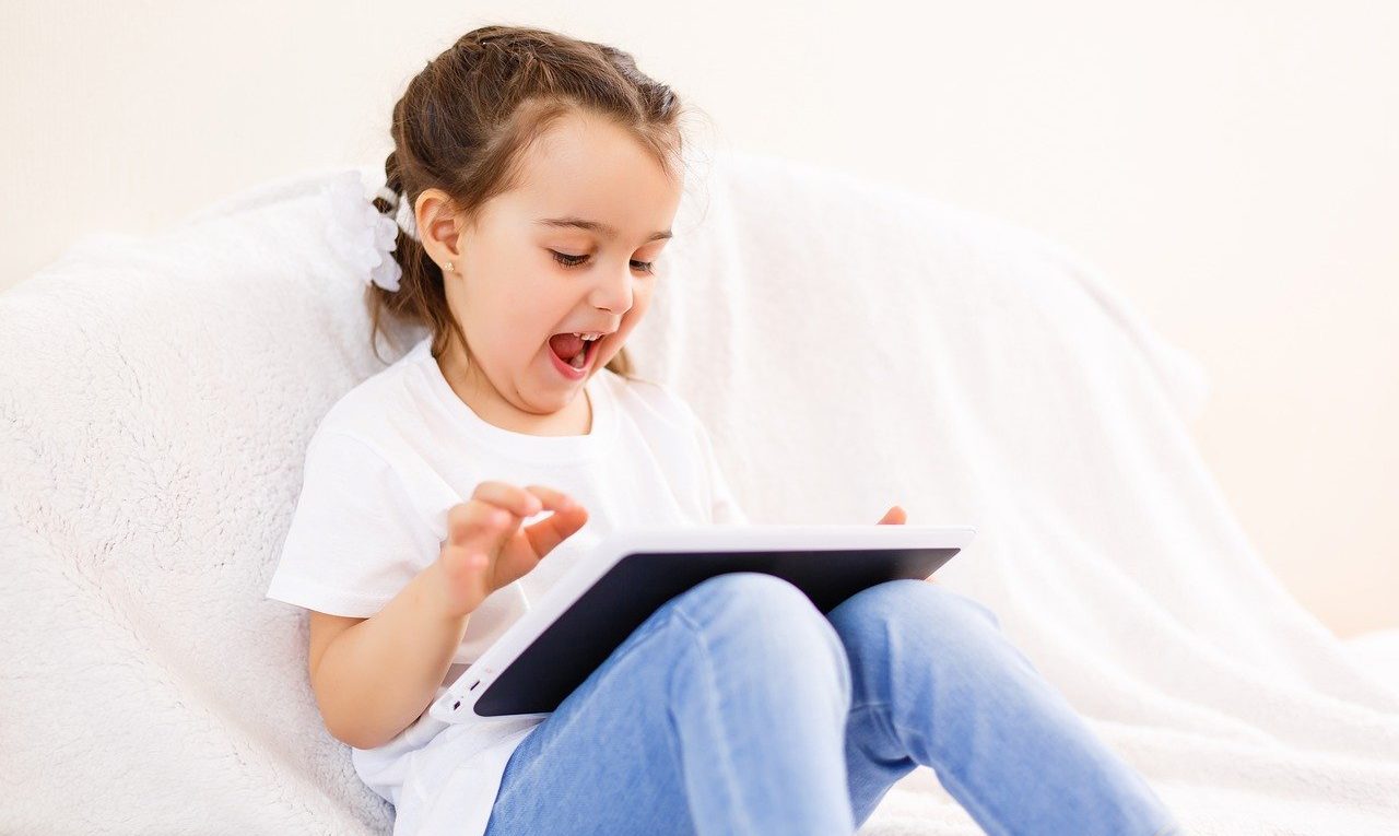 little girl playing on her tablet
